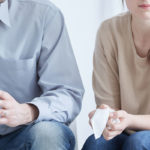 a woman holds a tissue during a meeting about divorce